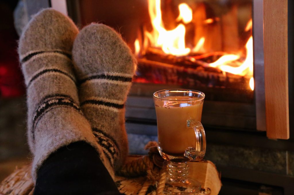 flickering flames - Feet in wool socks warming at the fireplace witch coffee